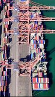 Aerial views showcase a large container ship unloading cargo at a busy port, with dock workers managing operations in a dynamic logistics environment video