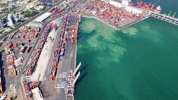 Cranes maneuvering shipping containers at a busy port efficiently load and unload cargo from large vessels, showcasing the dynamic nature of maritime logistics video