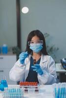 Group of dedicated scientist conduct chemical experiment in medical laboratory, carefully drop precise amount of liquid from pipette into test tube for vaccine drug or antibiotic development. Neoteric photo