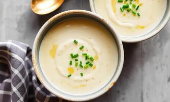 Two bowls of creamy soup with green onions photo