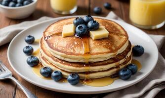 A stack of pancakes with blueberries and butter photo