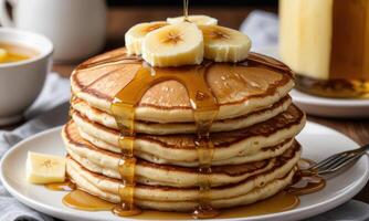A stack of pancakes with bananas and syrup photo
