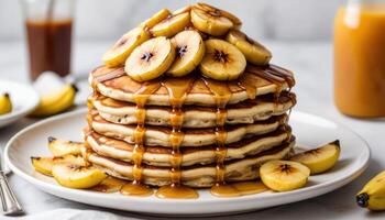 A stack of pancakes with bananas and syrup photo