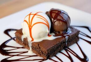 A brownie with ice cream and chocolate sauce photo