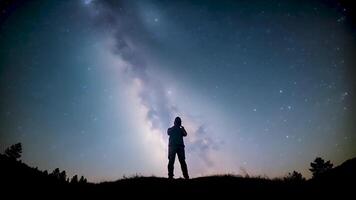 Man's silhouette under a spotlight set against a backdrop of twinkling stars, reflecting themes of introspection and cosmic wonder. video