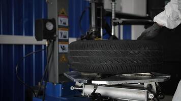 Mechanic handling car tire on a machine in a workshop video