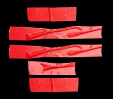 Top view set of wrinkled red adhesive vinyl tape or cloth tape in stripes shape isolated on black background with clipping path photo