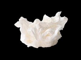 Side view of screwed or crumpled white tissue paper ball isolated on black background with clipping path photo
