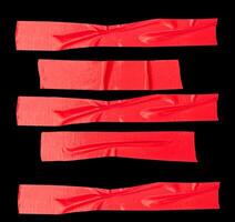 Top view set of wrinkled red adhesive vinyl tape or cloth tape in stripe shape isolated on black background with clipping path photo