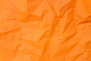 Top view and full frame of wrinkled or crumpled orange paper texture used as crumpled paper background texture in decorative art work. photo