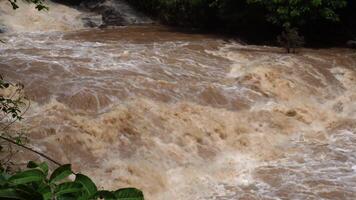 A strong current near a waterfall. Floods flowing in mountain rivers after heavy rains. Flash floods, the effects of global warming and the effects of deforestation. video