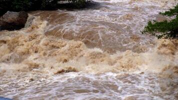 A strong current near a waterfall. Floods flowing in mountain rivers after heavy rains. Flash floods, the effects of global warming and the effects of deforestation. video
