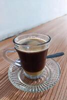 Coffee and milk have not been stirred in a glass on the table photo