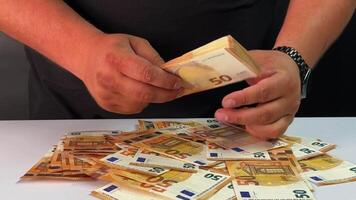 Hands are sorting through various euro banknotes on a table, focusing on the meticulous arrangement of the currency. A careful and slow process is taking place video