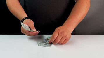 A person is carefully counting dollar bills on a white surface, emphasizing financial organization. Their focus highlights the importance of managing money effectively video