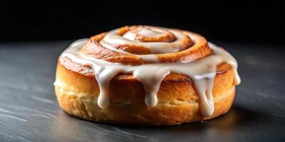 Delicious cinnamon roll with icing on dark background photo