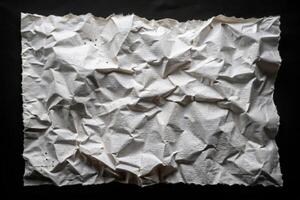 Crumpled and torn perforated paper sheet isolated on black eye level photo