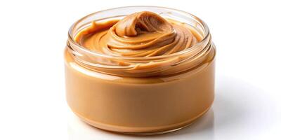Creamy peanut butter spreading into a jar on white background photo