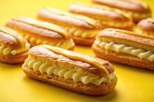 Delicious eclairs with custard on yellow background at eye level photo