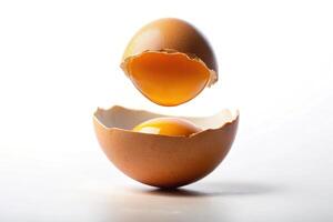 Levitating asymmetrical broken egg on white background photo