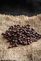 Freshly roasted coffee beans spread on burlap fabric in natural light just after brewing photo