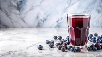 Refreshing blueberry juice in a glass on marble surface with white copy space photo