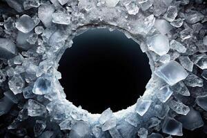 Round hole in ice with crushed ice shards on black background photo