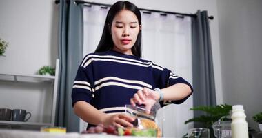 Handheld low angle view shot, Young Asian woman prepare food and snack into plate on table ready for lunch at home. Lifestyle at home video
