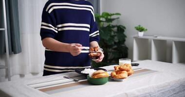 Handheld shot, Young Asian woman arranging food bowls for lunch on dining table at home. Lifestyle at home video