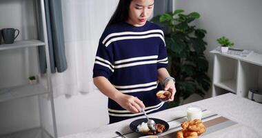 Handheld high angle view shot, Young Asian woman arranging food bowls for lunch on dining table at home. Lifestyle at home video