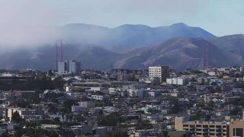 Aerial view of the Golden Gate Bridge surrounded by Fog in San Francisco, California, USA. View from the downtown of San Francisco with houses and buildings in the foreground. video