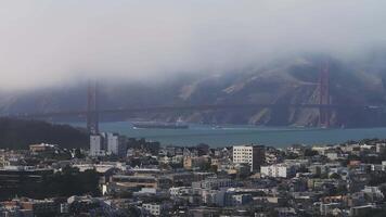 Aerial view of the Golden Gate Bridge surrounded by Fog in San Francisco, California, USA. View from the downtown of San Francisco with houses and buildings in the foreground. video
