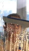 A child looking through a window with a window cleaner video