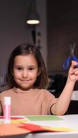 vertical portrait of little girl posing holding scissors in hand video