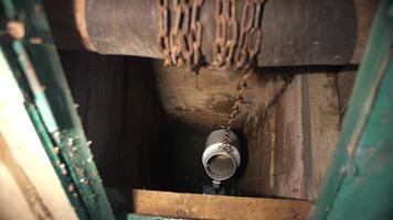 pov process of raising water from a village well with a bucket on a chain video