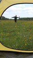 vertical Happy man running through a grass field with yellow flowers video
