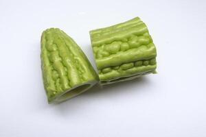 Light green pieces of Momordica charantia fruit on white background. Another name is Chinese bitter gourd, Balsam pear, Bitter cucumber, Bitter gourd, Leprosy gourd. photo