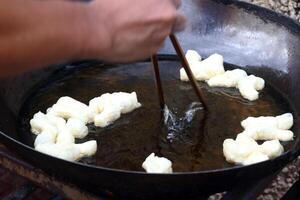 Pathongko deep fried in pan with hand flipping in Thailand. photo