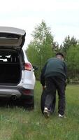 vertical driver takes out spare tire from the trunk of car. flat tire video
