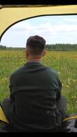 vertical man sitting in a tent enjoying the view of field and forest, wildlife video