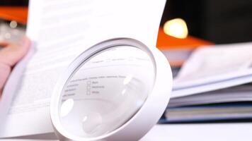 using a magnifying glass to look at a document video