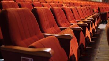 row of empty spectator chairs with raised seats in an empty auditorium video