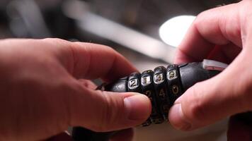 male hands hold a combination lock with numbers for a bicycle. Open it up video