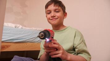 close-up of a boy with a red electric screwdriver turned on video