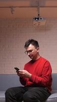vertical Man typing a message while watching a movie in a home theater video