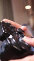 vertical close-up of a black gamepad, a console controller in the hands video