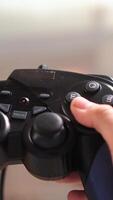vertical close up of hands and gamepad - Using controller playing games video