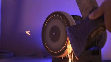 close up of sharpening an axe on a machine with a grinding stone. Sparks video