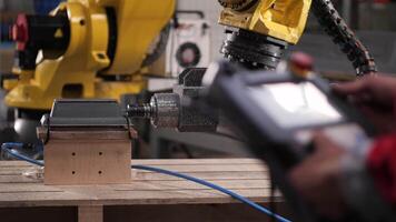 Worker operates control panel of robotic machine at car manufacturing video