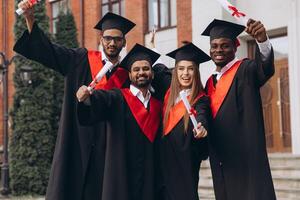 Group of Diverse Happy Graduates Celebrating Achievement Outside University in Cap and Gown photo